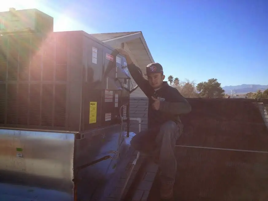 HVAC technician performing Air Duct Repair on a rooftop unit in Sun City West